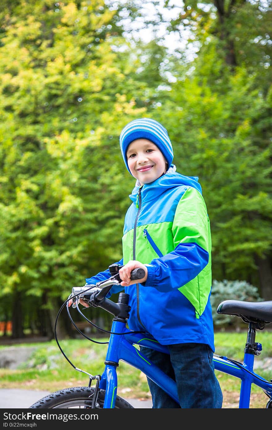 Kid boy outdoor in park with bike. Kid boy outdoor in park with bike.