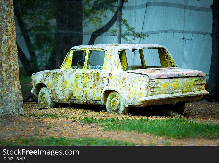 An old rusty car in paint from paintball.