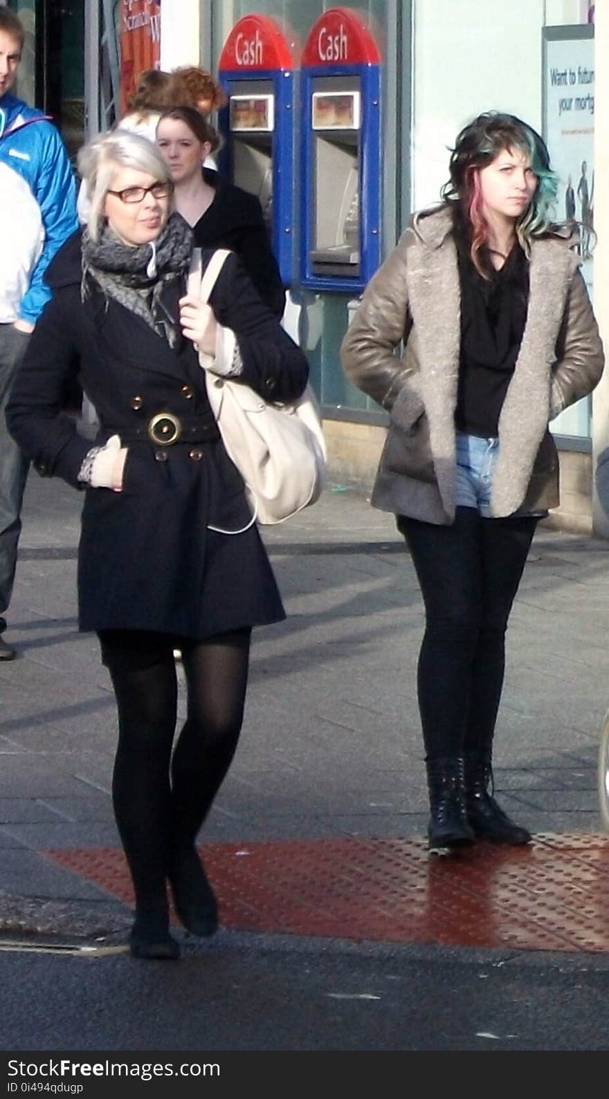 two women waiting to cross road. two women waiting to cross road