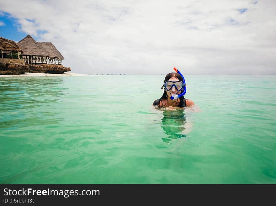 Happy woman wearing a mask for snorkeling in the turquoise ocean on the island of Zanzibar. Copy space. Happy woman wearing a mask for snorkeling in the turquoise ocean on the island of Zanzibar. Copy space