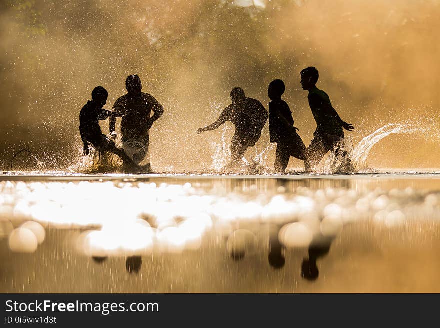 Boys playfully splashing water on each other on holiday.