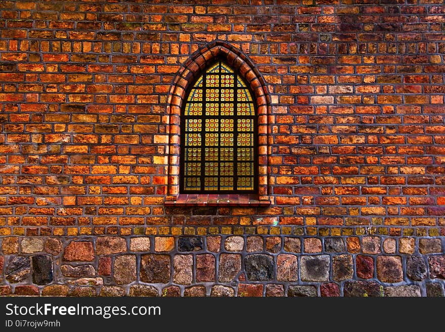 Composite image of stained glass window set in ancient window arch of an old church. Composite image of stained glass window set in ancient window arch of an old church