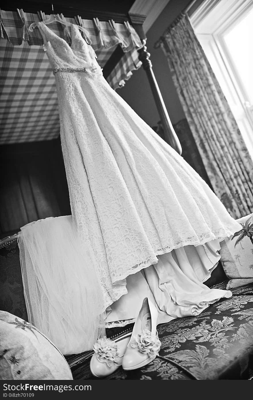 Stunning wedding dress hanging of a bed frame.