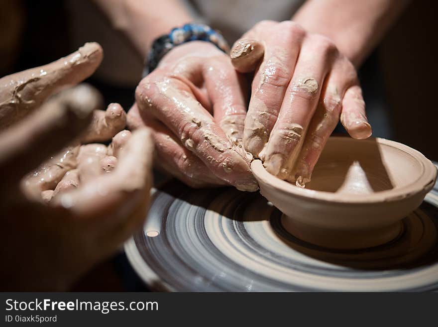 Child learns to make pottery on the potter`s wheel