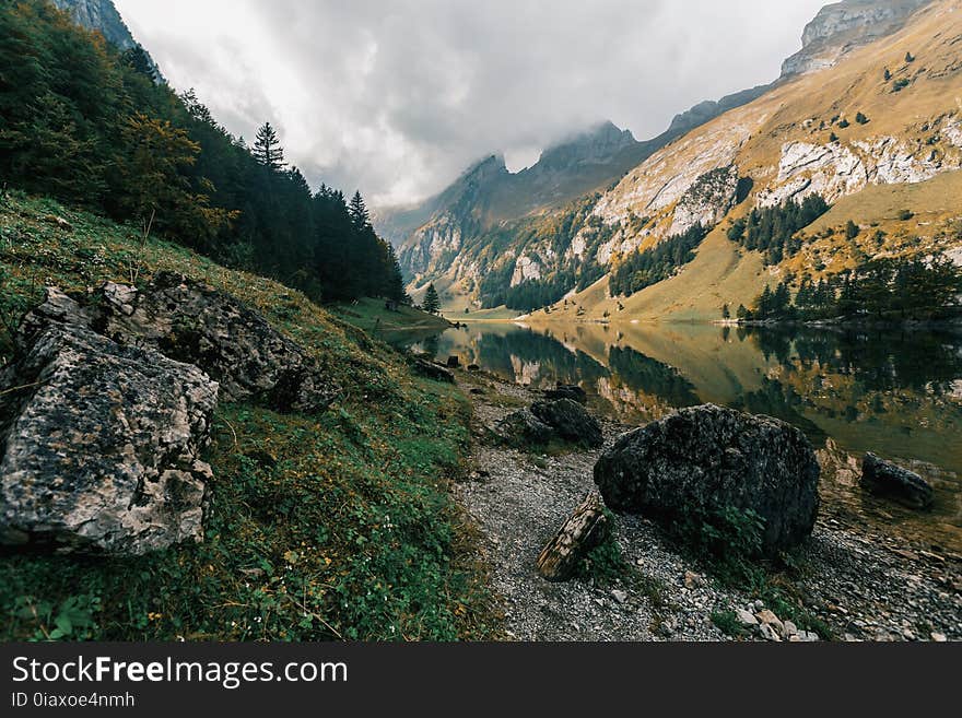 River Between Mountains Under Cloudy Sky