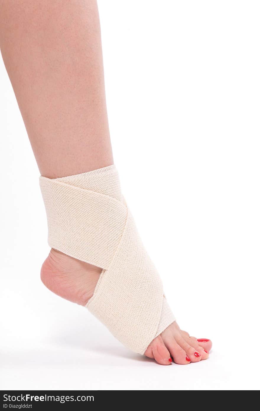 Women`s leg tied with an elastic bandage, ankle foot.