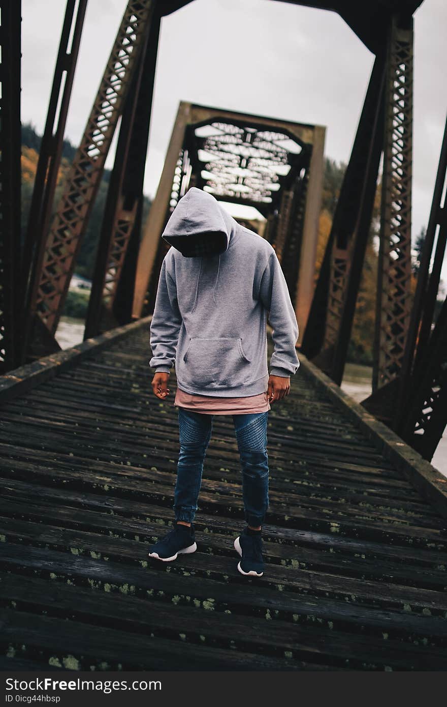 Man in Gray Pull-over Hoodie Standing on Train Rail