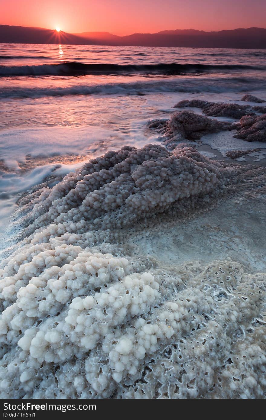 Majestic sunrise over Jordan mountains lighting the salt crystals forming on the dead sea shores. Majestic sunrise over Jordan mountains lighting the salt crystals forming on the dead sea shores