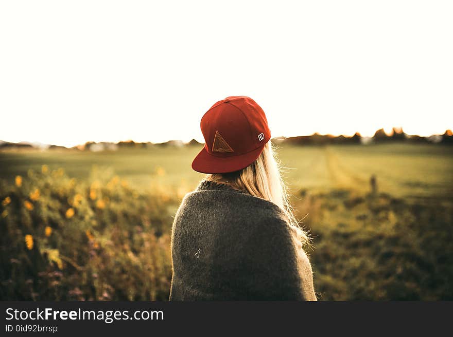 Woman in Gray Cardigan and Red Snapback Cap