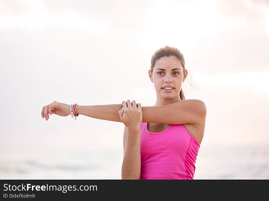 Photography of Woman in Pink Tank Top Stretching Arm