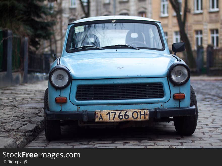 Classic Blue Car Parked Near Fence and Trees