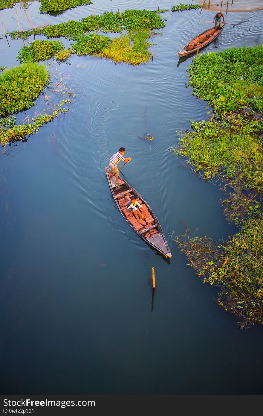 Two Person Riding Black Wooden Boats