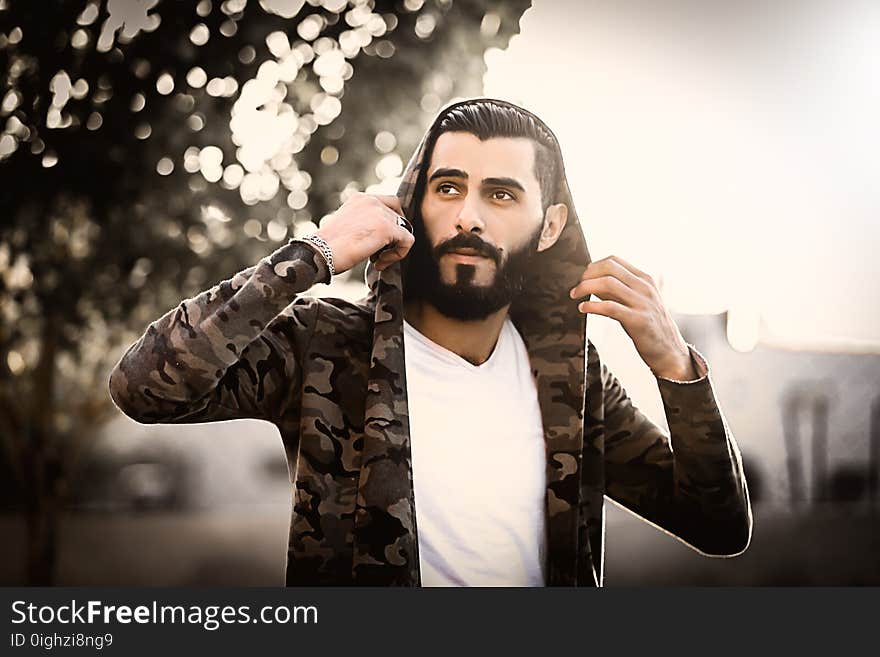 Man Wearing Camouflage Hoodie and White Shirt