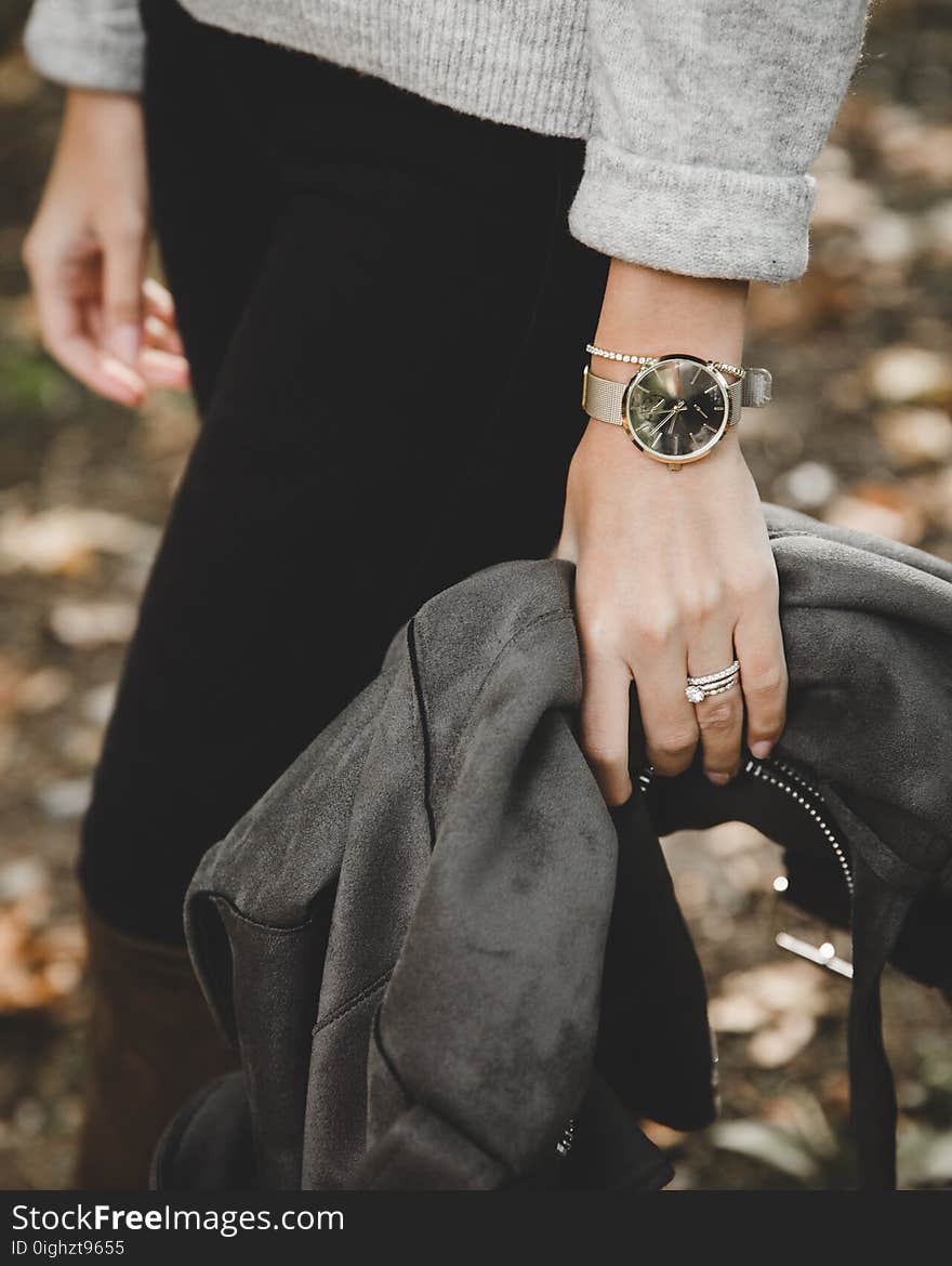 Person Wearing Gray Knit Sweater Holding Black Leather Jacket