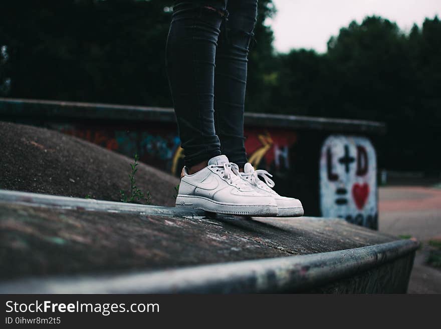 Human Standing on the Ground and Wearing White Nike Sneakers