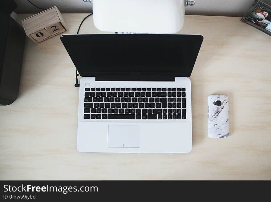 Macbook Beside Smartphone on Desk