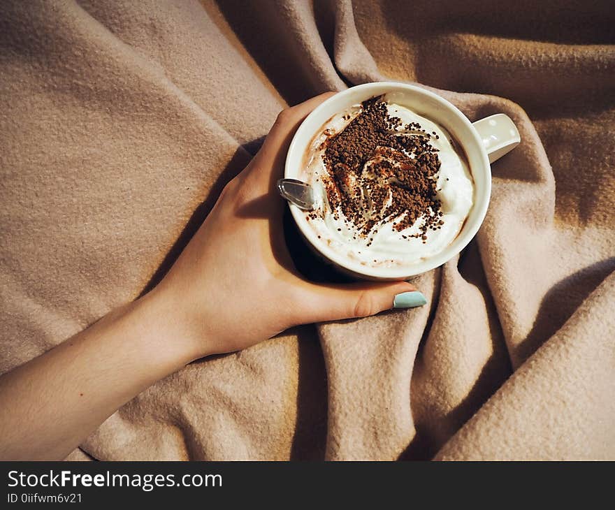 Person Holding Cup With Coffee Latte With Spoon Inside