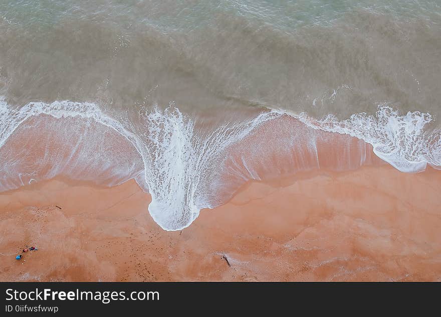 Calm Body of Water Beside Sand