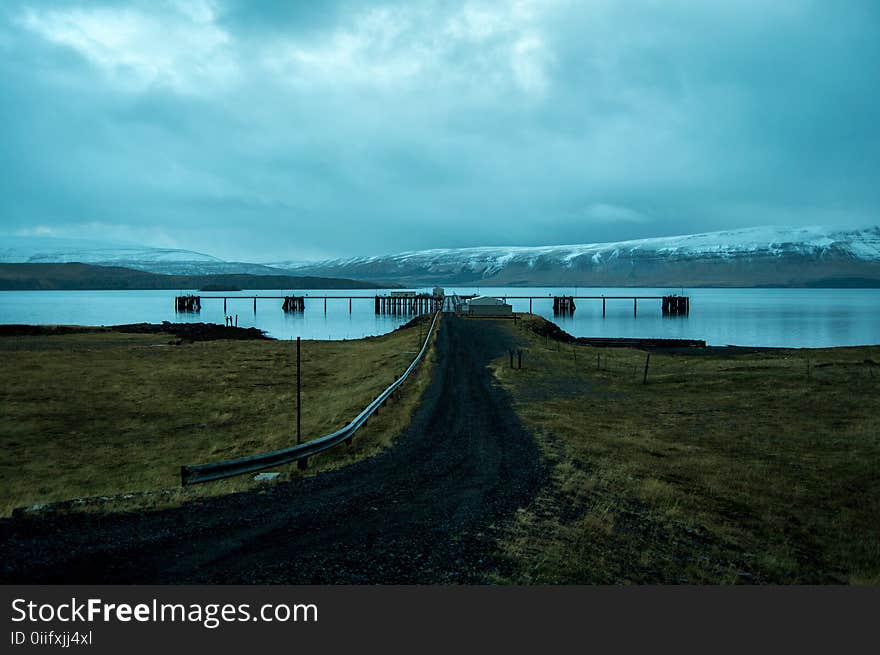 Brown Dock Near Snow Mountain at Daytime