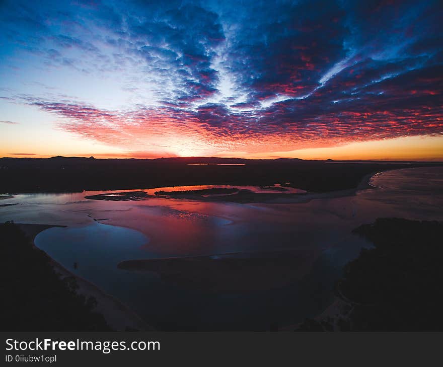 White Sand Beach Under Cloudy Sky during Sunset