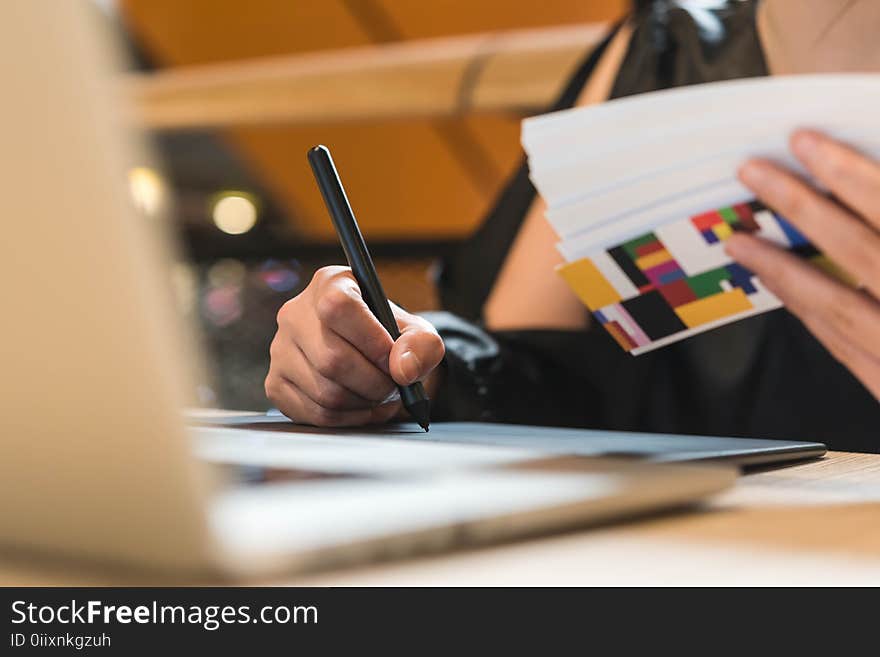 Close up hands of beautiful asian woman designer in black dress working with mouse pen while look at color chart