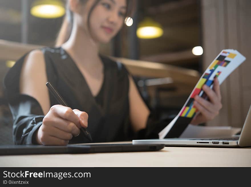 Beautiful asian woman designer in black dress working with mouse