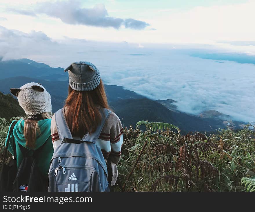 Two Woman Wearing White and Gray Crater Hat