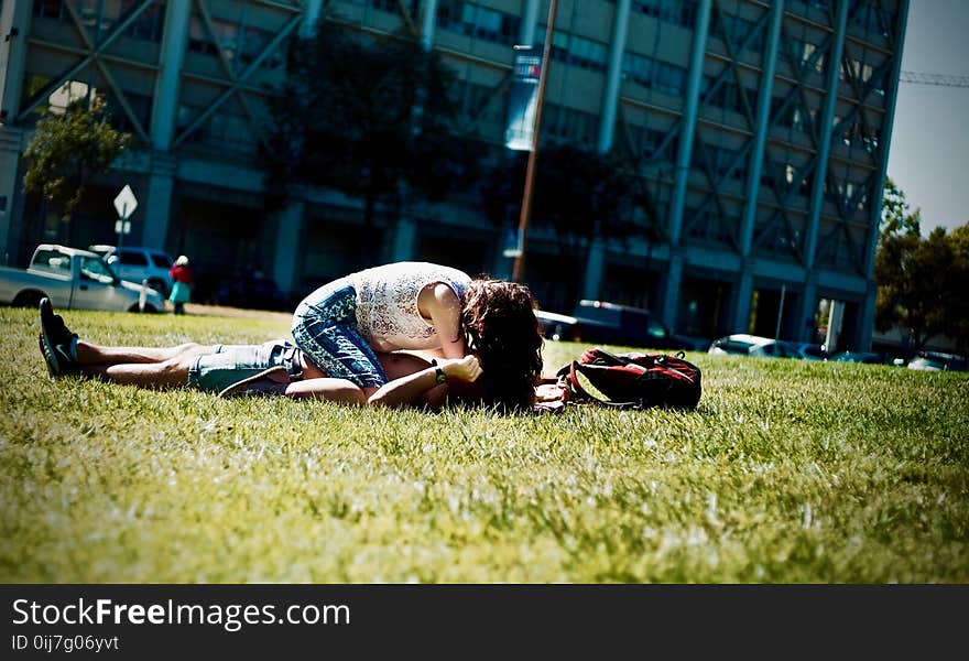 Man and Woman Lying on Green Field