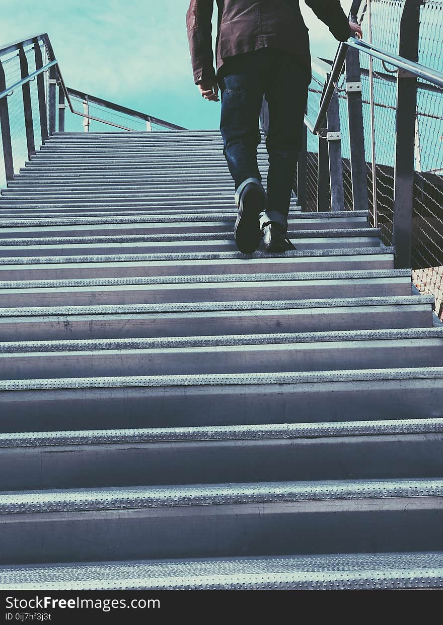 Man Walking on Gray Stairs