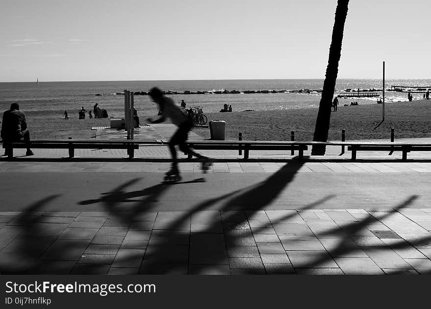 Person Skating on Road in Grayscale Photography