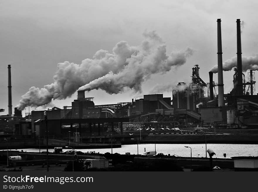 Grayscale Photography of Locomotive Train Beside Factory