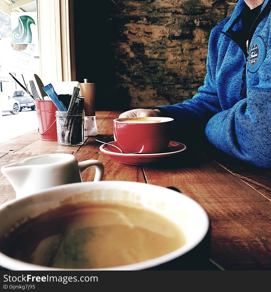 Person Wearing Blue Jacket Holding Red Cup