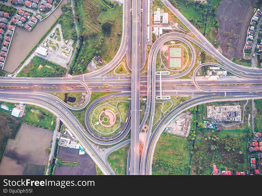 Aerial view of urbal highway intersection road with green exercise background