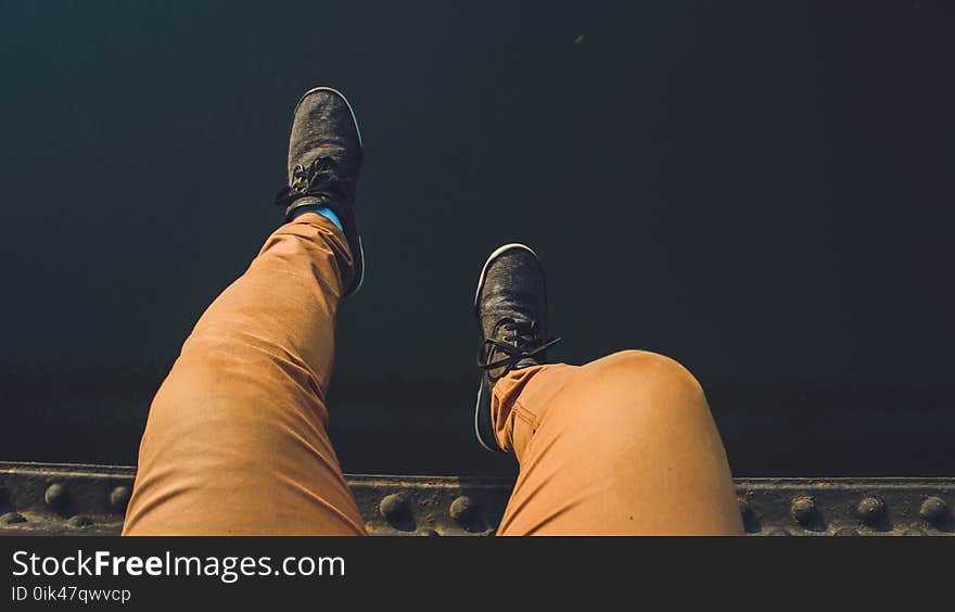 Person Wearing Brown Jeans With Pair of Black Sneakers