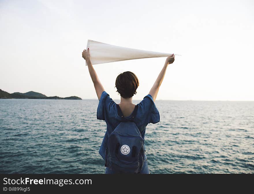 Person In Blue Short Sleeved Shirt Holding White Cloth