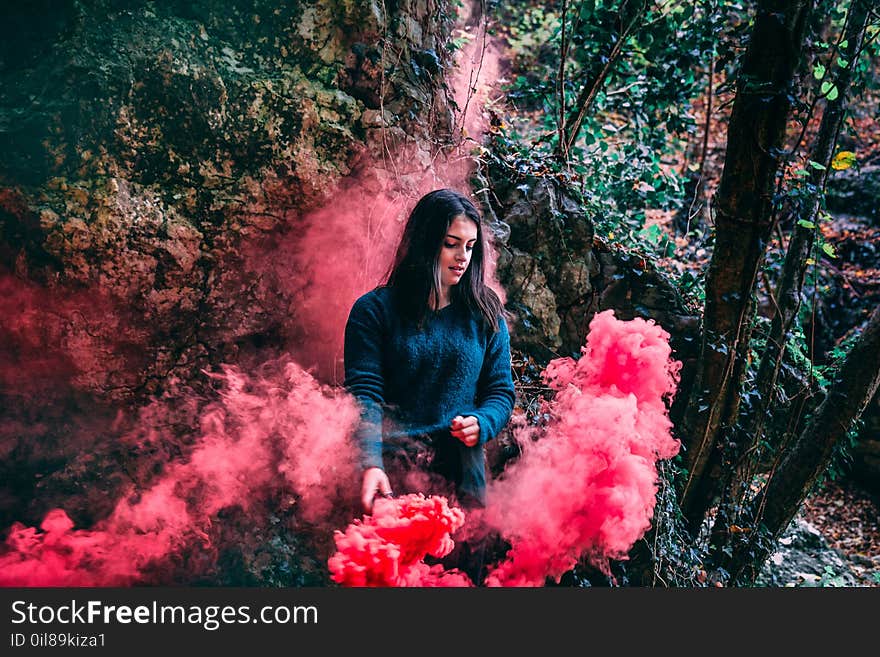 Woman Wearing Blue Long Sleeved Shirt Standing On Pink Smoke