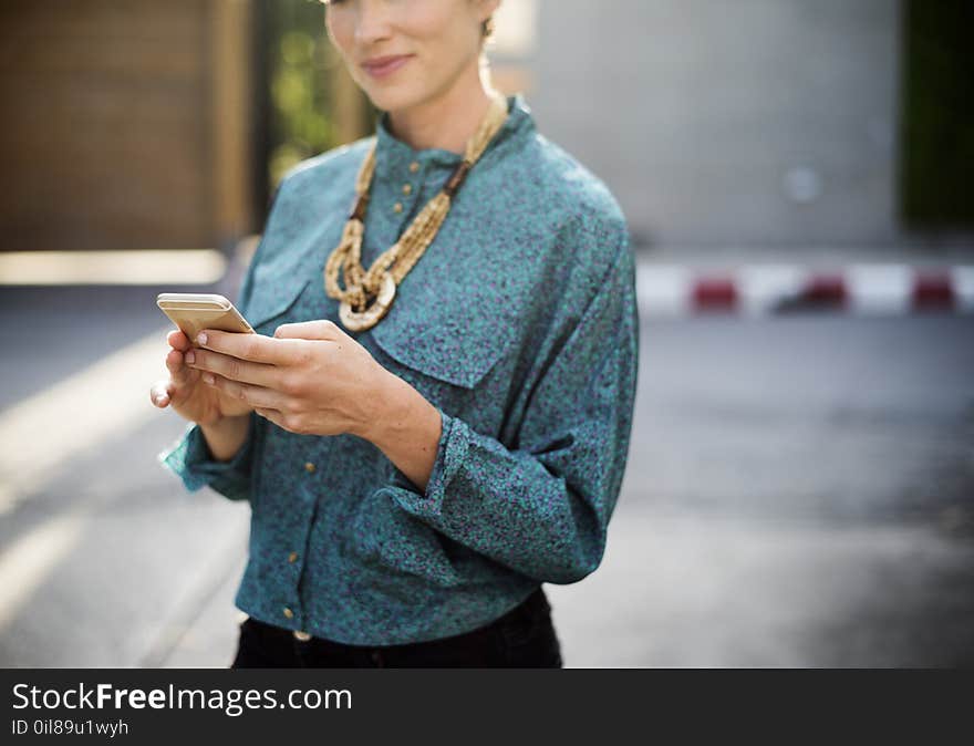 Woman Holding Iphone Wearing Long-sleeved Shirt And Gold Necklace