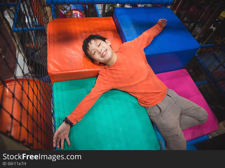 Boy lying on colorful floor at indoor playground