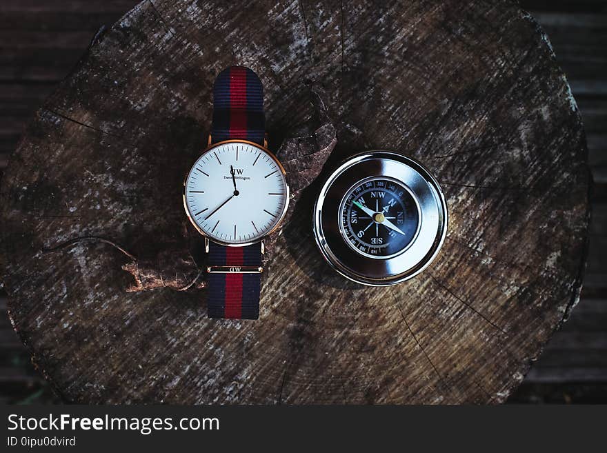 Round Silver-colored Analog Watch Beside Compass