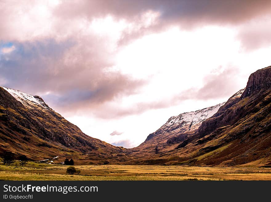 Grass Field Between Two Mountains