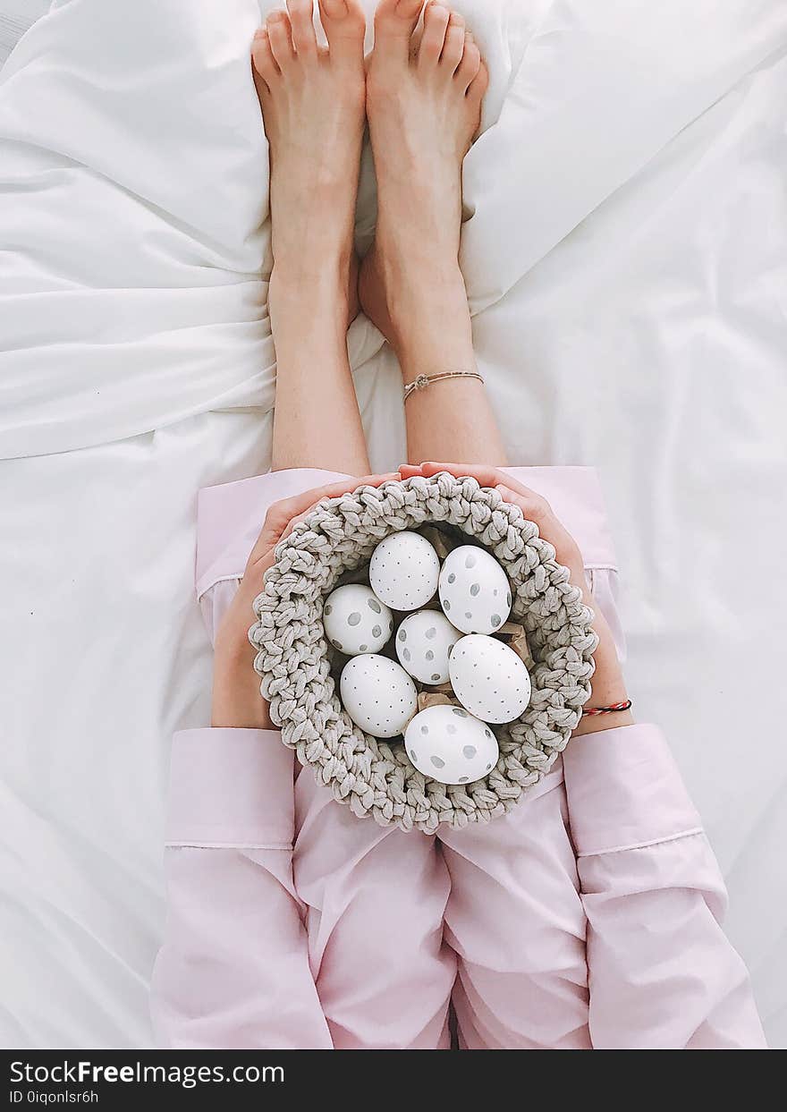 Woman Holding Gray Crochet Bowl With Seven Painted Eggs