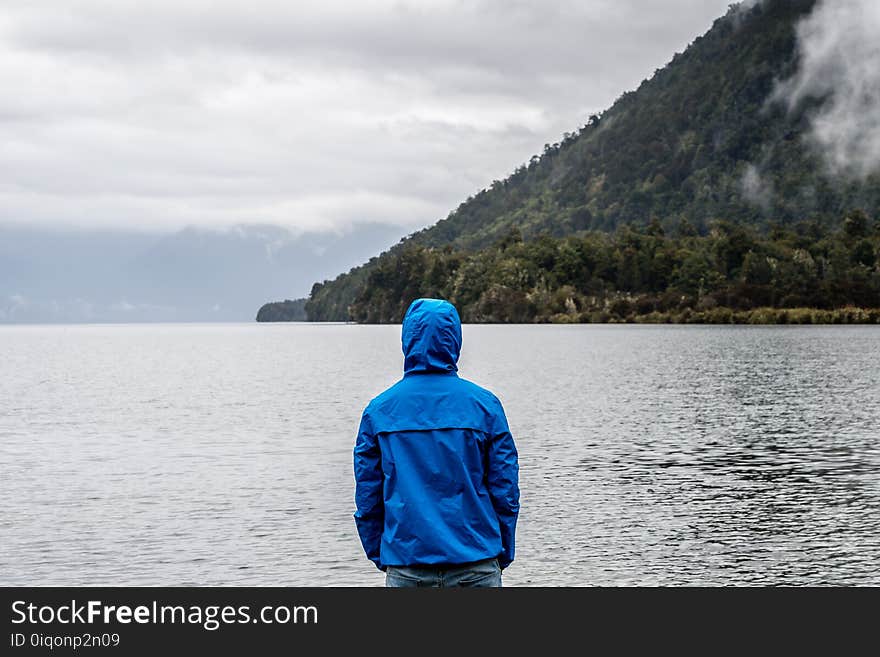 Person Wearing Blue Hoodie Near Body of Water