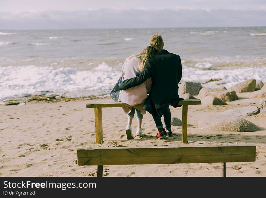 Man and Woman Hugging and Sitting on a Bench