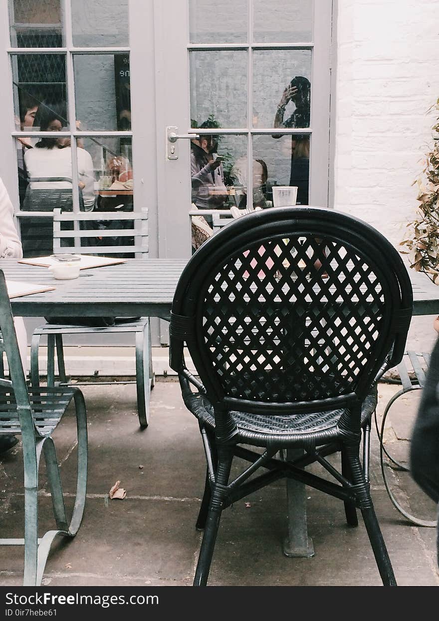 Black Metal Chair Beside Table at Daytime