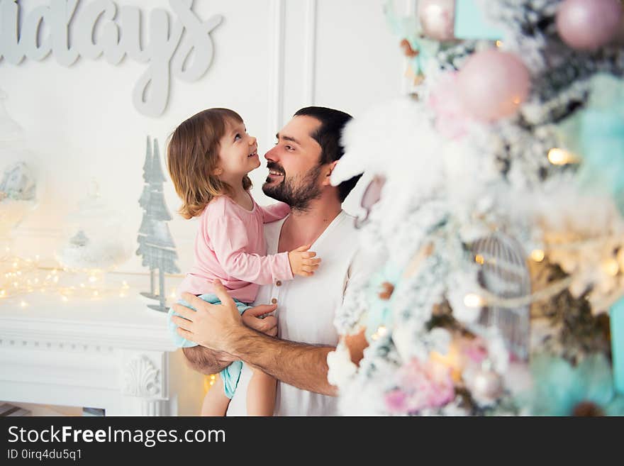 Little daughter and father near Christmas tree. Happy New Year