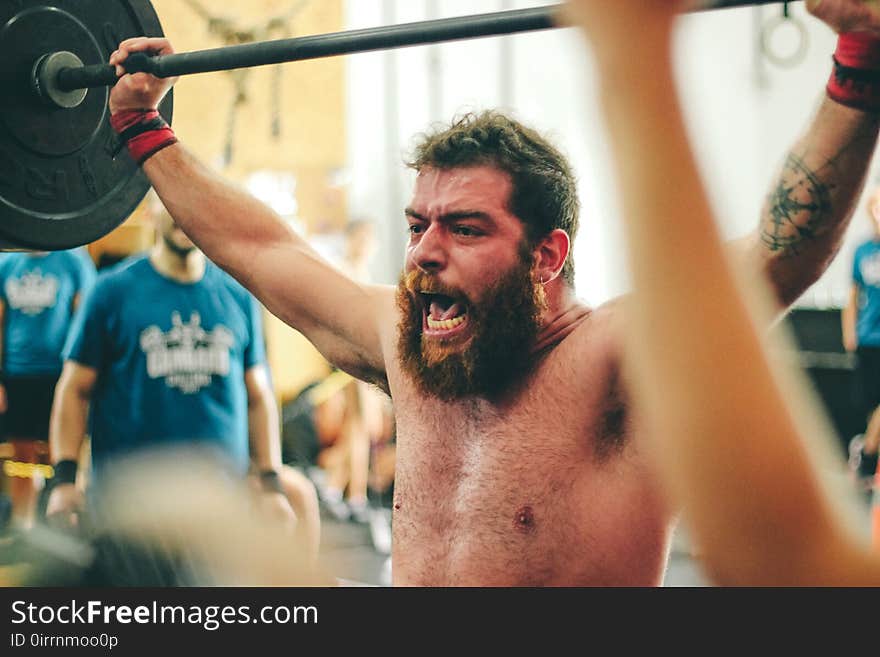 Man Carrying Black Barbell