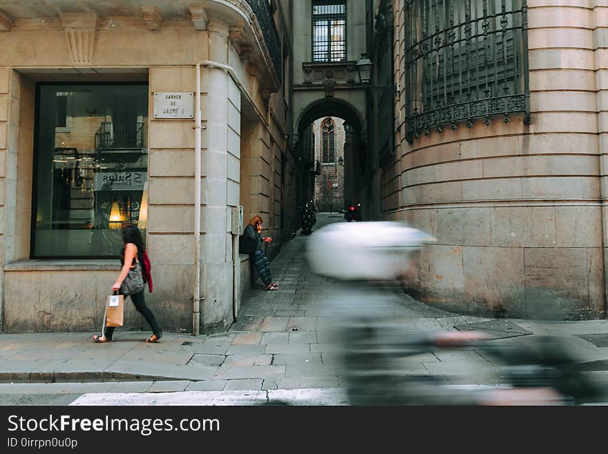 Woman in Black Walking Near Glass Window