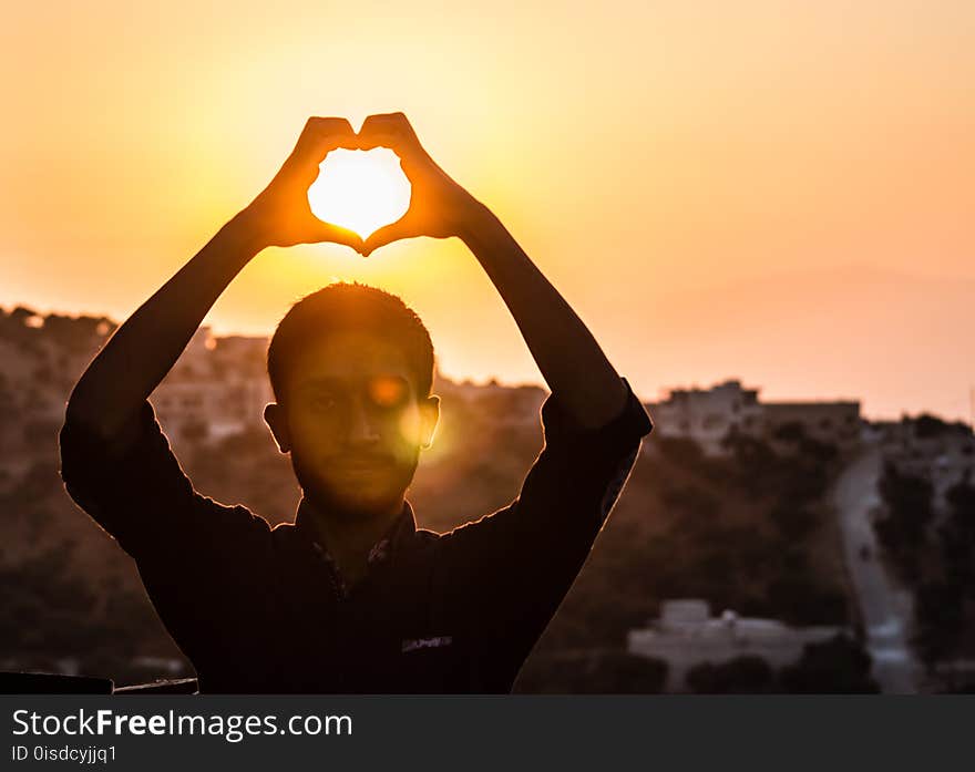 Person Making Heart Shape With His Hand During Sunset