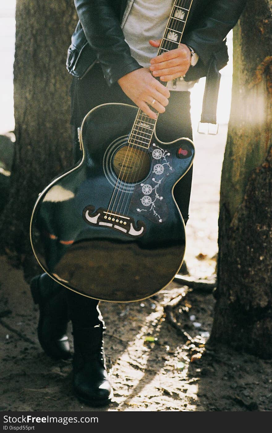 Man Holding Single Cutaway Acoustic Guitar