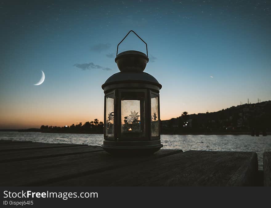 Gray Metal Candle Lantern on Boat Dock